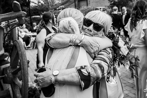 Emotional embrace at outdoor wedding.