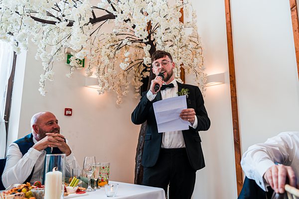 Man giving speech at wedding reception.