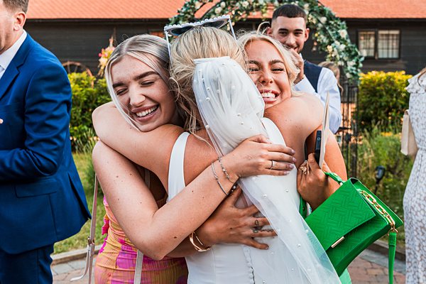 Joyful wedding hug with bride and friends.