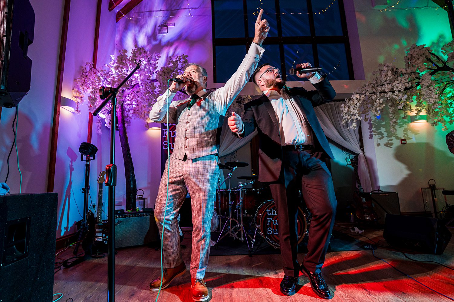 Two singers performing live at an event.