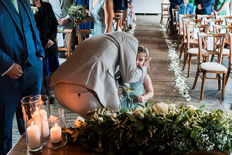 Child hugging at wedding ceremony.