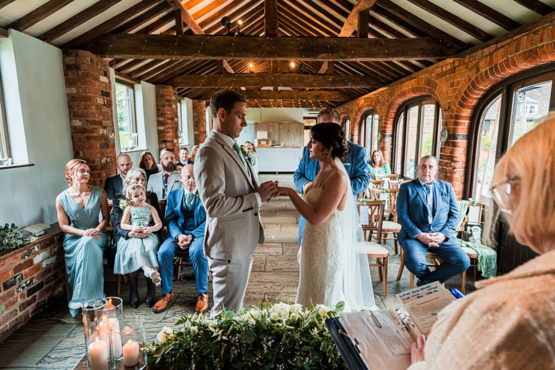 Couple exchanging vows at rustic wedding ceremony.
