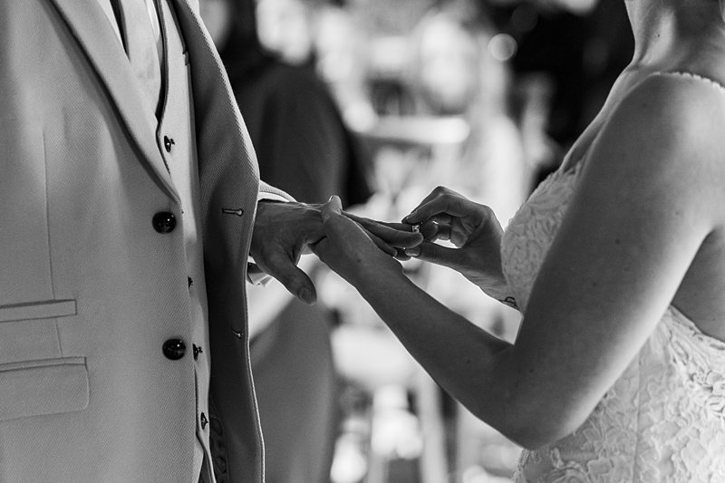 Wedding ring exchange close-up in black and white.