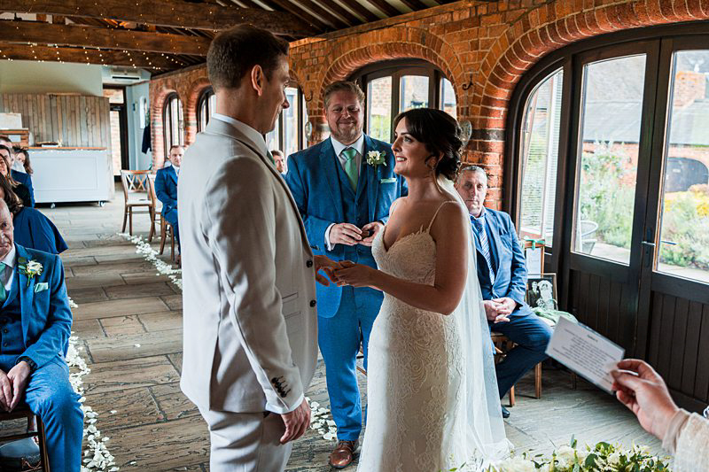 Bride and groom exchanging rings at wedding ceremony.
