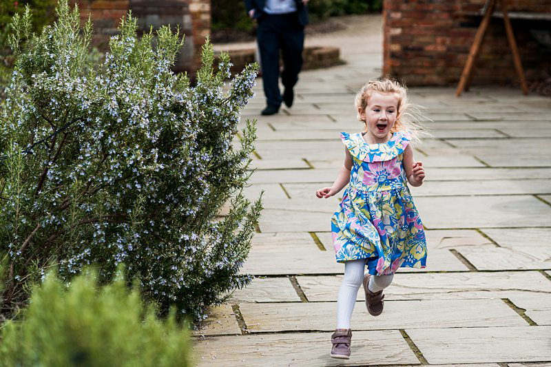 Girl running joyfully in garden.