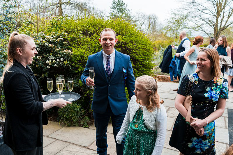 Guests enjoying outdoor wedding reception with champagne.