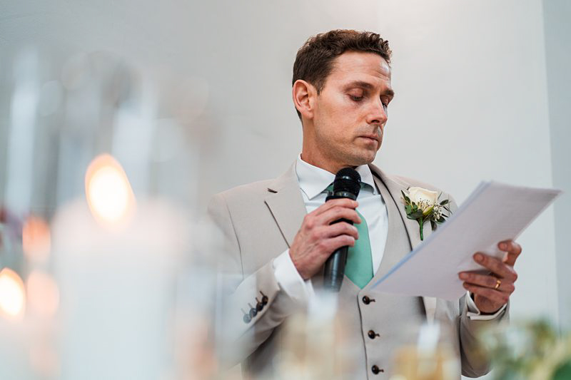 Man giving speech at wedding ceremony.