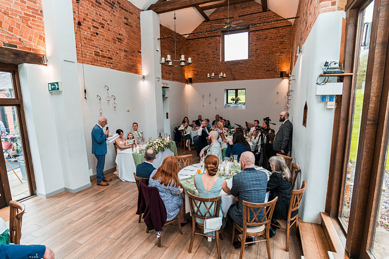 Wedding reception speech in rustic venue