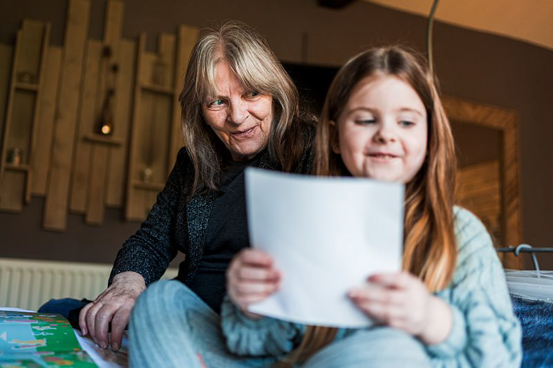 Grandmother and granddaughter reading together indoors.