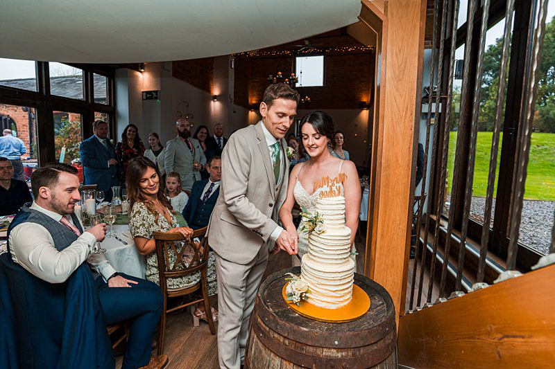 Couple cutting wedding cake at reception.