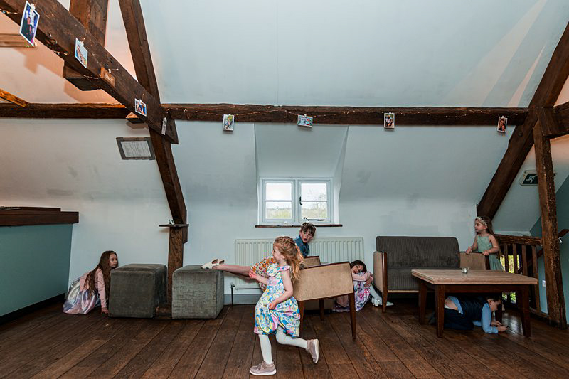 Children playing hide and seek in attic playroom.