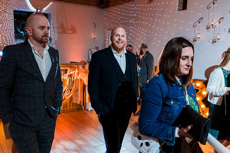 Guests at festive event with decorative lighting.