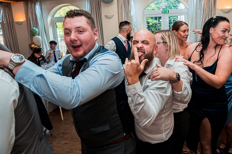 Wedding guests dancing and enjoying reception party.