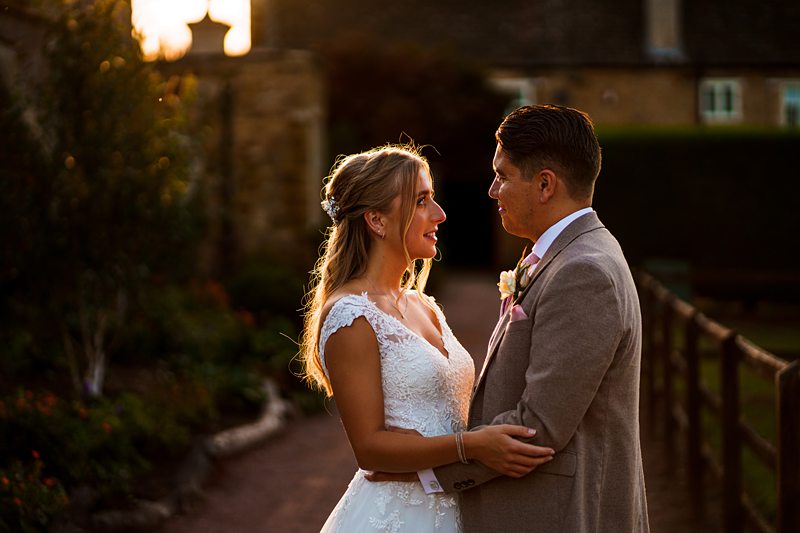 Bride and groom embracing at sunset wedding.