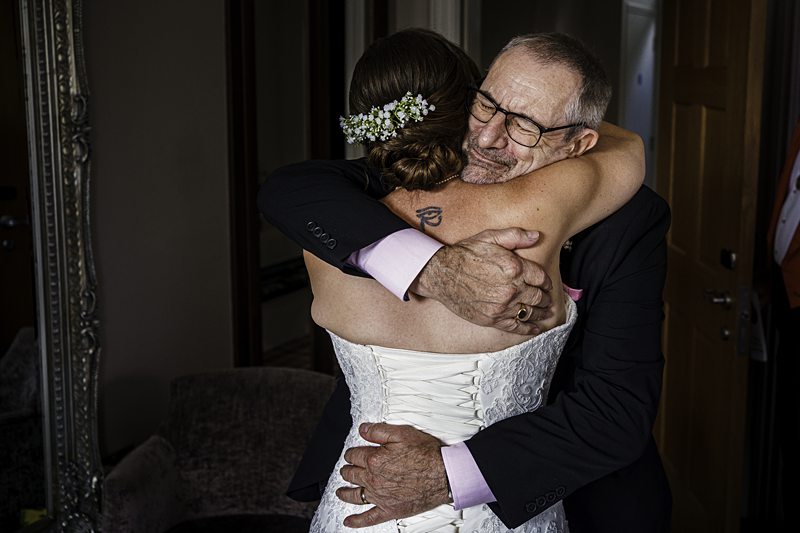 Bride embracing older man at a wedding.