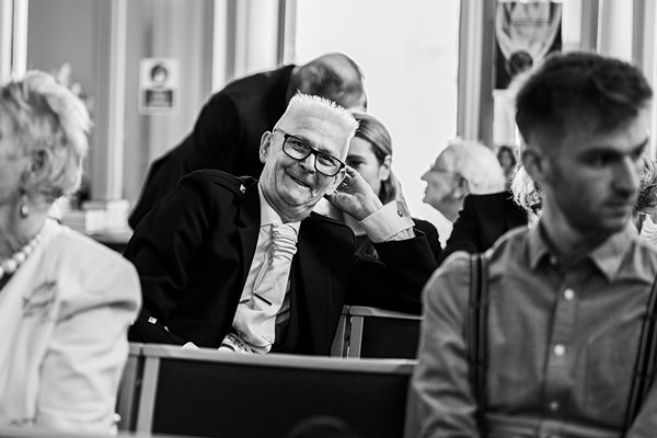 Smiling man in glasses at social event.