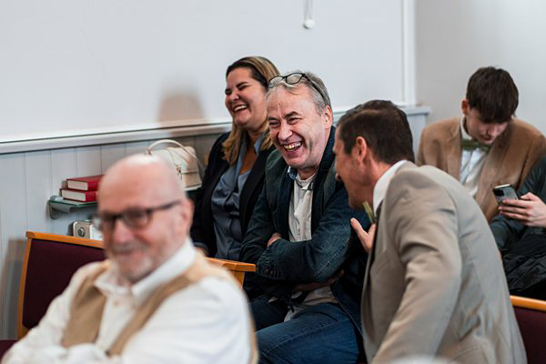 Group of people laughing together indoors.