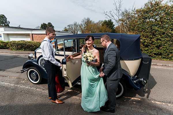 Woman in green dress by vintage car