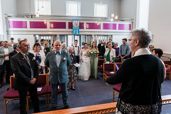 Wedding ceremony in church with guests and couple.