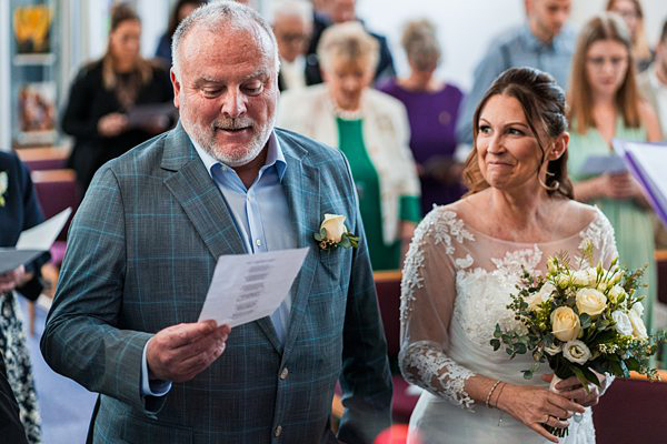 Bride and groom smiling during wedding ceremony.
