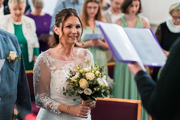 Bride with bouquet at wedding ceremony.