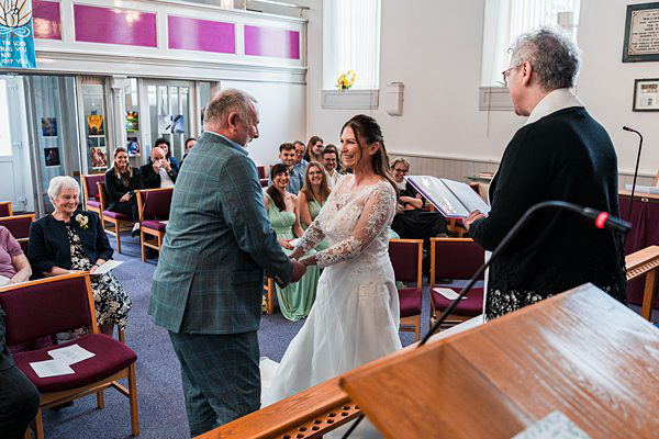 Bride and father walking down aisle in church wedding.
