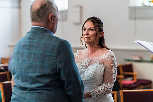 Bride exchanging vows with groom in church wedding