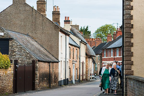 Elderly women walking down quaint British village street.