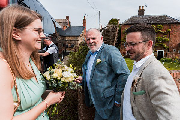 Guests smiling at garden wedding reception.