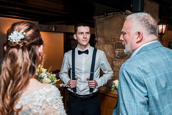 Wedding guests conversing in rustic venue.