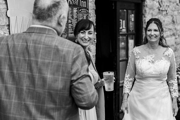 Wedding guests smiling near pub entrance