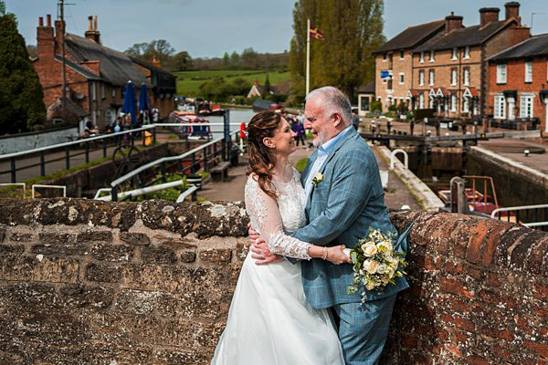 Couple embracing at canal lock wedding.