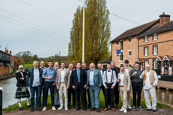 Group of men posing by a canal.