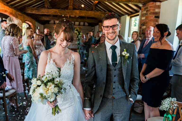 Happy bride and groom at wedding ceremony aisle.