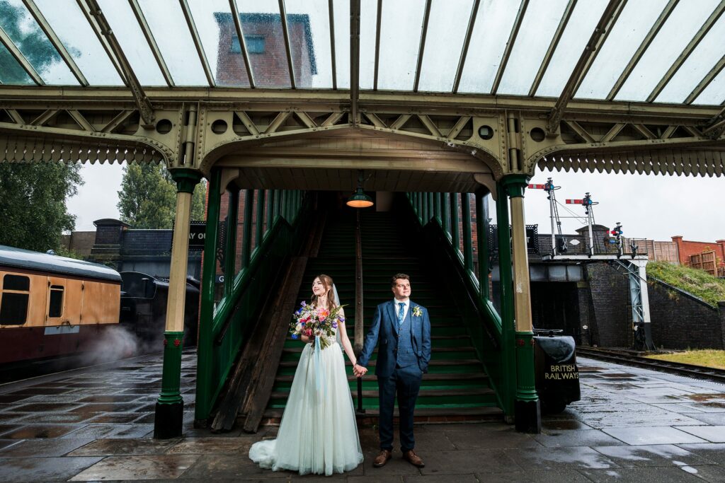 Bride and groom at vintage railway station.