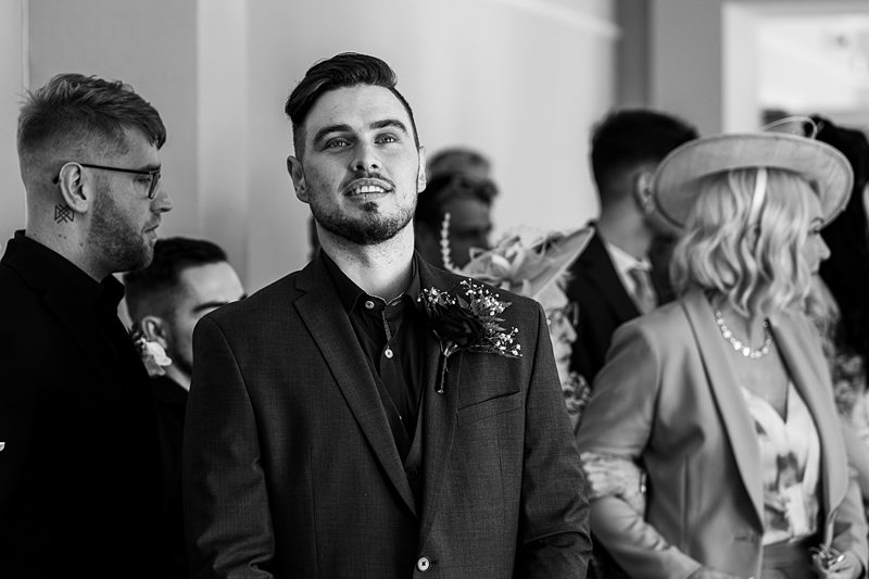 Man in a suit at a wedding ceremony.