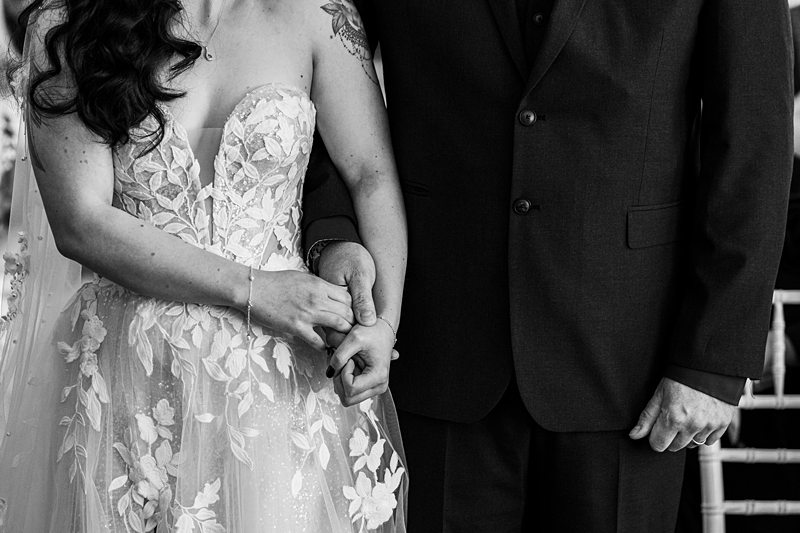 Bride and groom holding hands in wedding ceremony.