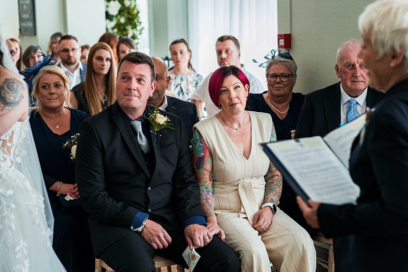 Wedding ceremony with guests intently listening.