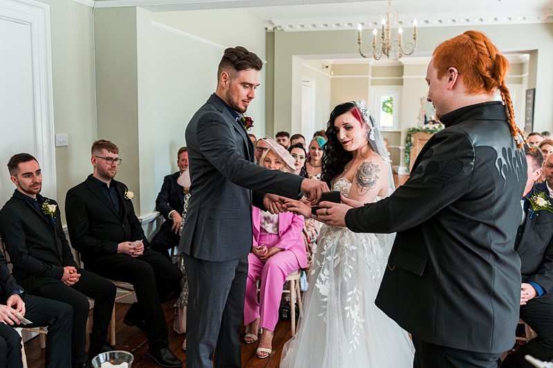 Wedding ceremony with guests, exchanging vows.