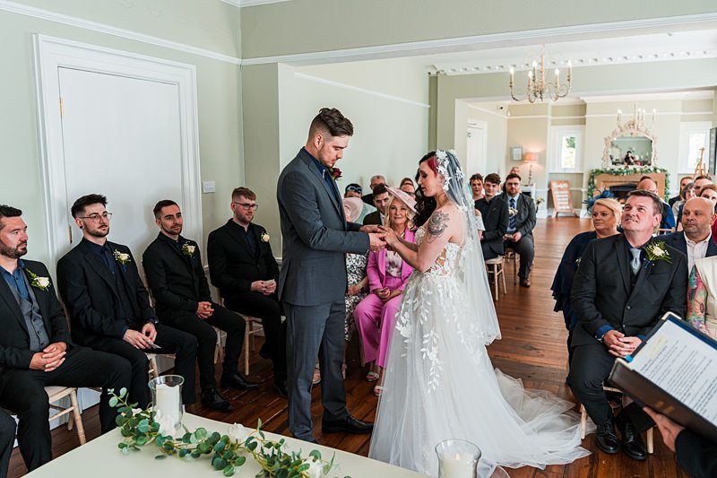 Bride and groom exchanging vows during indoor wedding ceremony.