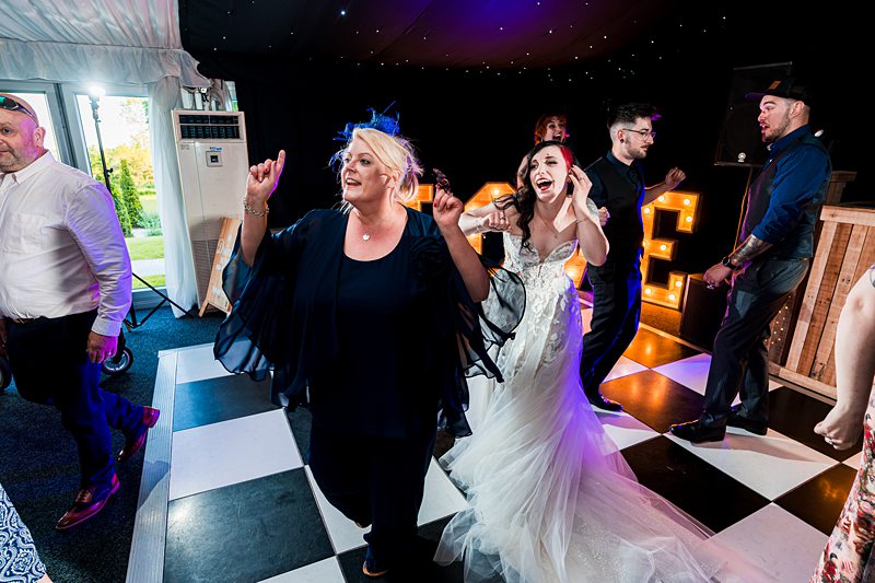 Wedding reception dance floor celebration with guests and bride.