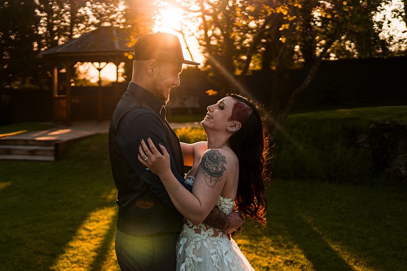 Couple sharing a moment at sunset in a garden.