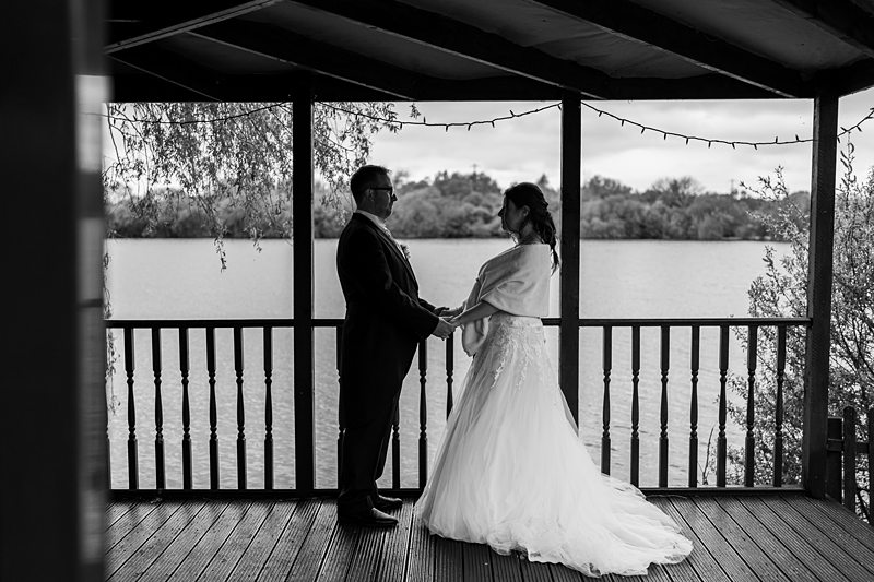 Wedding couple standing by the lake, holding hands