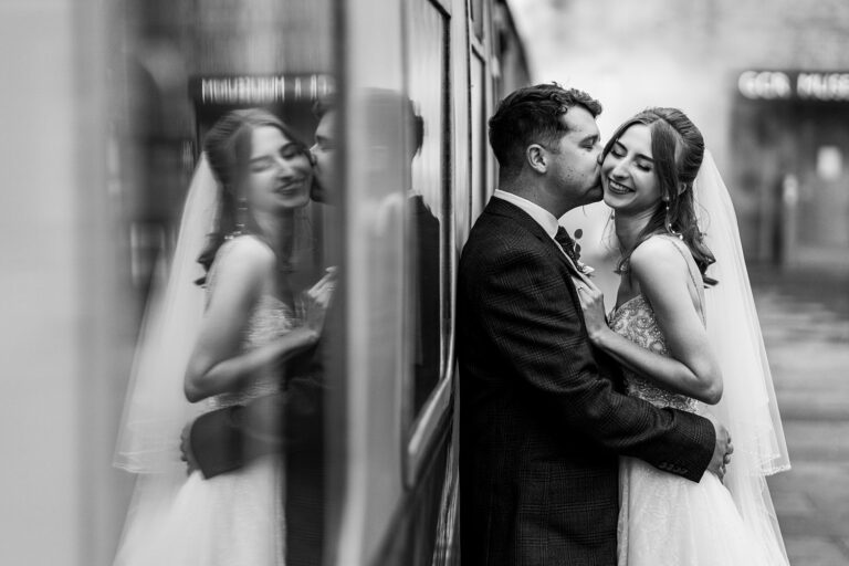 Bride and groom embrace, smile, black and white photo.