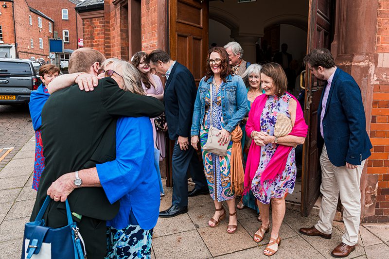 Group of people hugging outside a building.