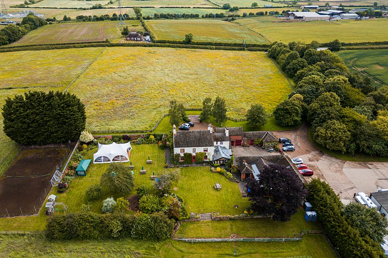 Aerial view of countryside house and fields