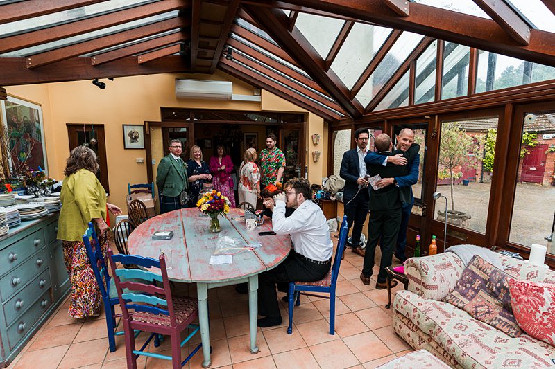 People socialising indoors around a large table.