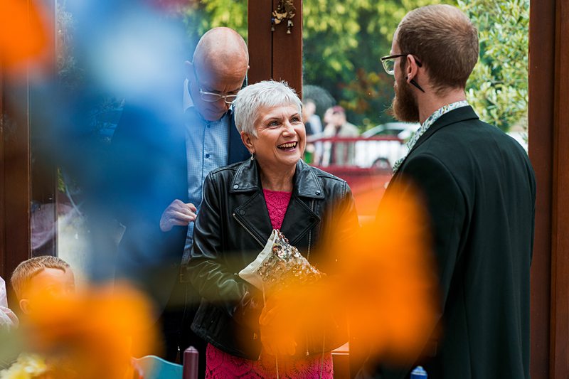 Smiling elderly woman holding bouquet, chatting with man.