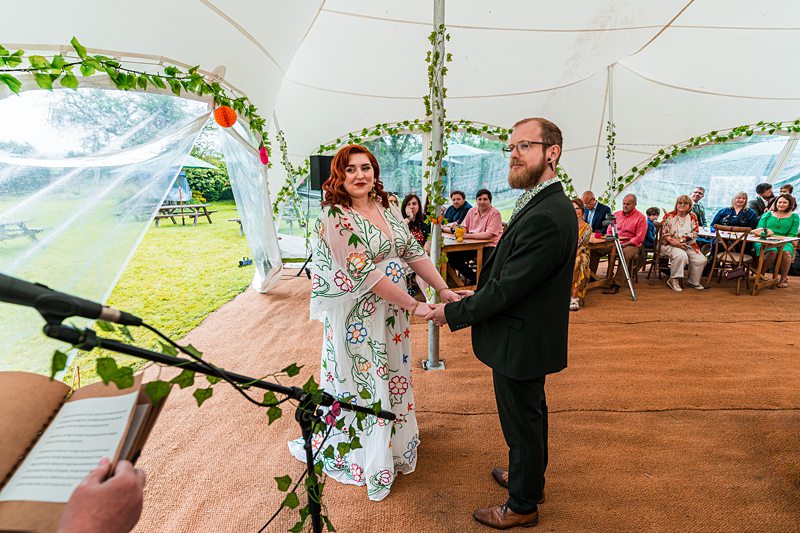 Outdoor wedding ceremony under tent.
