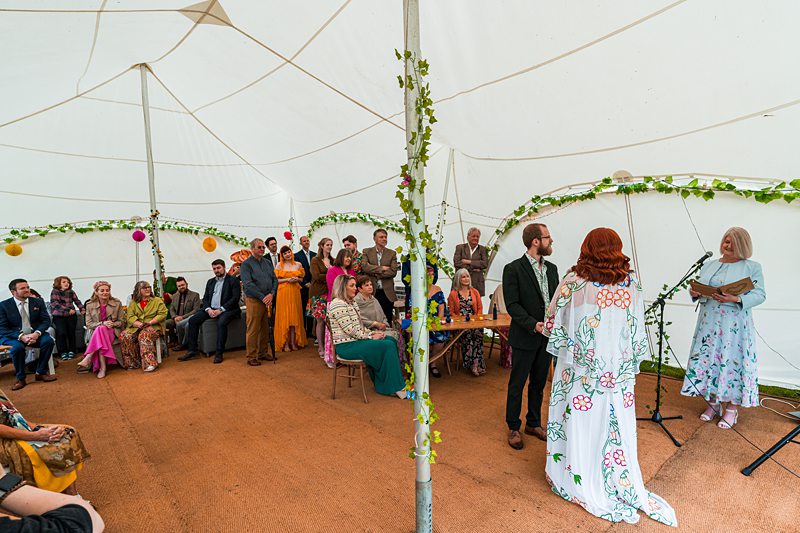 Wedding ceremony in a decorative tent with guests.